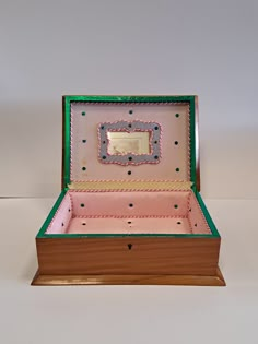 an open pink and green box on a white surface