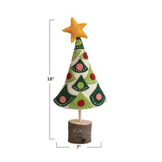 a small green christmas tree on top of a wooden stump with a star above it