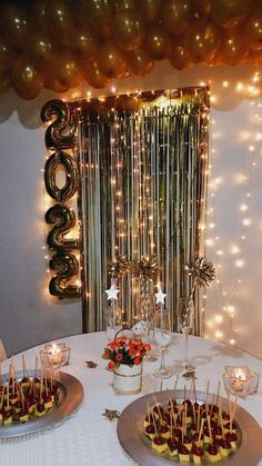 two desserts on plates sitting on a table in front of balloons and streamers