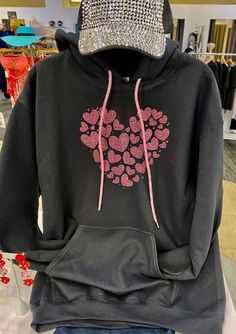 "Rhinestone hearts hoodie, Bling pink hearts hoodie, Valentines day hoodie, Hearts bling hoodie with bling drawstring Super cool rhinestone rose pink heart on black hoodie. We make the multi heart with rose pink rhinestones. They are super sparkly rhinestones, and so is the drawstring! The drawstring is rose pink also! Great Valentine's Day gift! This is a really pretty, pink heart. Pictures do not do it justice! We use high quality, multi-cut rhinestones for all our designs. These rhinestones a Black Hooded Sweatshirt Gift, Black Hooded Sweatshirt As Gift, Black Cotton Hoodie For Gift, Black Cotton Hoodie As Gift, Black Casual Hoodie As Gift, Casual Black Hoodie As Gift, Black Casual Sweatshirt Gift, Black Rhinestone Hoodie For Winter, Casual Hooded Sweatshirt For Valentine's Day