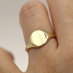 "With a history that stretches back to seemingly the beginning of time — think, 3500 B. C. — the signet ring is an important earmark in the evolution of metalwork and jewelry. Typically forged out of a thicker band and featuring a flat surface, the empty space on a signet ring is traditionally left blank so that the wearer can engrave their own personal mark.   Metal info. 14k Yellow Gold (Solid Gold) Face Up Size: 7mm * 9mm Ring Size (US) 2 - 11 High Polished Finish. All of our jewelry is handm Womens Gold Signet Ring, Solid Gold Signet Ring, Signant Ring Women, Women Signet Ring, Gold Signet Ring Woman, Signet Ring Women, Mark Metal, 9mm Ring, Oval Signet Ring