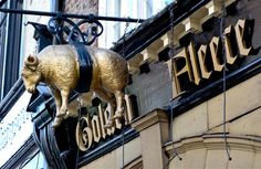 a golden pig hanging from the side of a building