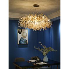 a chandelier hanging from the ceiling over a dining room table with blue walls