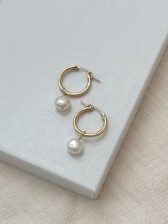 A classic pair of Pearl hoops has the power to elevate any outfit! The minimalist earrings design looks gorgeous paired with both casual and dressy outfits. The lightweight hoop latches to stay in place all day!  The Pearl charms can even be removed for a more casual look! * 18mm 14K Gold Filled or 925 Sterling Silver Hoops * 14/20 gf or 925 stamp for authenticity * Made with all hypoallergenic materials 🤍  ✨  Shop all Pearl earrings here!: https://etsy.me/3Xiy4c5 GET TO KNOW MAGBEE JEWELRY! ✨ Everyday Small Hoop Pearl Drop Jewelry, Modern Yellow Gold Hoop Earrings With Pearl Drop, Delicate Yellow Gold Hoop Pearl Earrings, Classic Hoop Pearl Drop Jewelry, Classic 14k Gold Hoop Earrings With Pearl Drop, Classic Dangle Hoop Earrings With Ear Wire, Nickel-free Classic Dangle Hoop Earrings, Everyday Hoop Pearl Earrings With Ear Wire, Everyday Pearl Hoop Earrings With Ear Wire