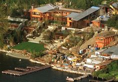 an aerial view of a large house on the water with lots of trees around it