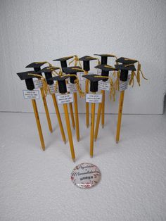 a group of yellow sticks with black graduation caps on them, tied to each other