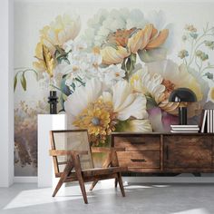 a wall with flowers painted on it next to a chair and bookcase in front of a dresser