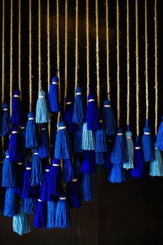 blue and gold tassels hanging from strings in the dark, close up view