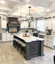 a large kitchen with white cabinets and an island