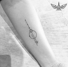 a small arrow tattoo on the forearm