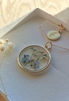 A beautiful and unique Botanical inspired terrarium necklace with real forget me not flowers and baby breath flowers (gypsophila) For memories of a close one, for true love and to show someone you will never forget them 💕The flower is encapsulated in a crystal clear Resin which is Non-toxic, No VOCs, No fumes, No solvents, Non-flammable, Non-hazardous, No BPA. The necklace chain is gold plated solid brass or stamped 14k gold filled chain as shown in last photo. This chain is much more long last Minimalist Birth Flower Jewelry Keepsake, Gold Sterling Silver Necklaces With Pressed Flowers, Gold Sterling Silver Necklace With Pressed Flowers, Dainty Birth Flower Jewelry For Keepsake, Birth Flower Round Pendant Jewelry For Bridesmaid, Delicate Sterling Silver Keepsake Necklace, Minimalist Birth Flower Necklace Keepsake, Pressed Flowers Keepsake Jewelry, Dainty Blue Birth Flower Jewelry