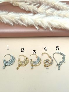 four pairs of earrings with different designs on them, one is gold and the other is silver