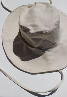 The Sun Hat in Natural from Pair Up. Made for sunny days — this extra wide hat will keep the rays off your cheeks and out of your eyes. Slightly stiffer brim that can be flipped up or down to create a few different looks. Easily removable chin strap, allowing you to adjust for a windy hike or relaxing pool day. Measurements Circumference: 23"Height: 3.5" Brim Width: 4" DEADSTOCK What is this? It's unused fabric that has been abandoned for a handful of different reasons. Brands might overestimate their needs, a fabric mill accidentally produces too much, or a dye house creates the wrong color. Whatever the reason, it needs to find a new home, and that's where Pair Up comes in. CARE Often times, it’s unclear what the actual material is and how it was dyed. That being said, we can’t guarantee Adjustable Beige Sun Hat For Travel, Adjustable Fit Beige Sun Hat For Travel, Natural Bucket Hat With Curved Brim For Outdoor, Adjustable Natural Color Bucket Hat For Everyday, Natural Curved Brim Bucket Hat For Outdoor, Spring Adjustable Fit Flat Brim Hat, Beige Flat Brim Bucket Hat For Travel, Natural Bucket Hat With Uv Protection Curved Brim, Adjustable Brimmed Bucket Hat With Uv Protection