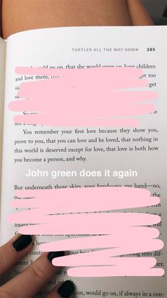 a person is holding an open book with pink paint on it and the words john green does it again