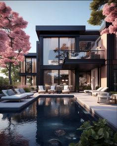 a large pool in front of a modern house with cherry blossoms on the trees around it