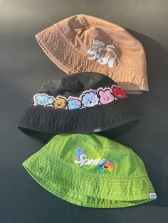 BTS hand embroidered and hand dyed bucket hats, perfect to rep your bias or your love for OT7! These are cotton bucket hats in a one size fits most sizing -Winter bear Taehyung V design on a light brown hat -BT21 baby design on a black bucket hat  -J-hope sprite design with hope world flower on a green bucket hat  Order your Hobi hat in time for lollapalooza! Playful Cotton Bucket Hat With Short Brim, Fun Cotton Hats For Streetwear, Fun Cotton Festival Hats, Trendy Summer Bucket Hat With Embroidered Logo, Cute Handmade Cotton Hat, Handmade Green Cotton Bucket Hat, Cute Streetwear Hats, Fun Handmade Cotton Hat, Handmade Casual Bucket Hat