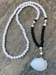 "Just a day at the beach! Light weight & comfortable I created this necklace with bright white wooden beads (8mm) black wooden beads (8mm) gold wooden beads (8mm) & a beautiful, perfect sea shell pendant This bohemian chic necklace measures 30 inches. Total hanging length from the nape off the neck to the end of the tassel is 18\" If you would like a different length, just message me 😊 Please take a few moments to browse through my shop. I have a large selection of unique belt bucks, le Gold Boho Necklace, Beaded Necklace White, Sea Shell Necklace, Chic Necklace, Seashell Necklace, Long Beaded Necklace, Wood Necklace, Necklace White, Simple Chic