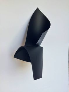 a black sculpture is hanging on the wall