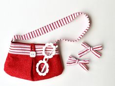 a red and white purse sitting on top of a table next to a pair of scissors