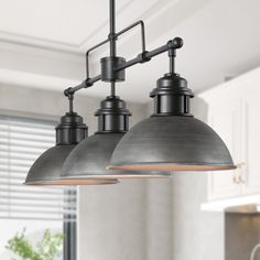 three lights hanging from the ceiling in a kitchen