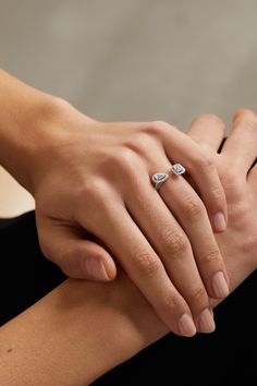 a woman's hand with two diamond rings on it