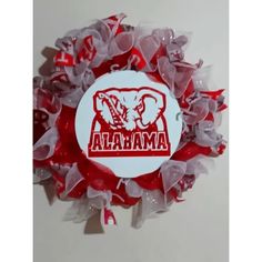 a red and white wreath with the word maaa on it's center piece