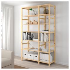 a book shelf with many books on top of it in a living room next to a couch