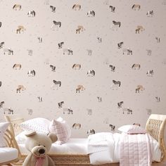 a teddy bear sitting in front of a wallpapered room with horses on it