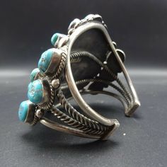 "MUSEUM WORTHY VINTAGE NAVAJO BRACELET DESCRIPTION: This exceptional cuff is from renowned Navajo artisan Jimmie Long who was active from the 1930s to the 1970s. Exquisite specimens of old Kingman turquoise are secure in smooth bezel, on a foundation of heavy gauge vintage sterling silver. Four bars of solid and twisted hand-pulled silver form the foundation, while applied raindrops and twisted silver adorn the face of the cuff. This museum quality bracelet will be a cherished addition to your c Antique Turquoise Adjustable Bracelet, Antique Adjustable Turquoise Bracelet, Vintage Turquoise Cuff Bracelet For Festival, Turquoise Vintage Cuff Bracelet For Festival, Vintage Turquoise Bracelet For Festival, Cluster Bracelet, Navajo Bracelet, Cluster Bracelets, Kingman Turquoise