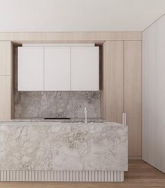 a kitchen with marble counter tops and white cabinets in the back drop off wall area