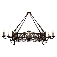 an iron chandelier with candles hanging from it's sides and a cross on the front