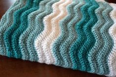 a crocheted blanket sitting on top of a wooden table