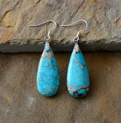 These natural stone earrings will "Cowgirl Up" any outfit. They are highly polished to bring out their natural lines and elegance. Size: 5.5cm Since each natural stone is unique (just like you ❤️), colors and shape will vary slightly from earring to earring, making this beautiful handmade item truly one of a kind. Coast Cowgirl, Treasure Jewelry, Natural Turquoise Stone, Turquoise Drop Earrings, Natural Stone Earrings, Imperial Jasper, Estilo Boho Chic, Teardrop Dangle Earrings, Boho Dresses