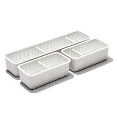 three white plastic containers with dividers on the bottom and one is filled with compartments