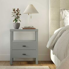 a bedroom with a bed, nightstand and lamp