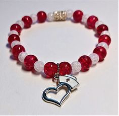 Honor your favorite nurse with this red and white glass crackle beaded bracelet.  Red 8mm beads and white 7mm beads in alternate pattern.  Love a Nurse dangling charm is 11mm silver heart with a white nurse's hat and universal symbol.  Great gift for birthdays, anniversaries, holidays and special occasions. Can also be worn as an ankle bracelet.  Handmade by Grandma B. Red Beaded Bracelets With Charms, White Heart-shaped Jewelry With 8mm Beads, White Charm Bracelet With Faceted Round Beads, White Charm Bracelet With Round Beads For Valentine's Day, White Charm Bracelet With Heart And Round Beads, Red Bracelets With Heart Charm And Round Beads, White Beaded Bracelets With Charms And Round Beads, White Jewelry With Heart Beads For Healing, White Hypoallergenic Heart Charm Bracelet