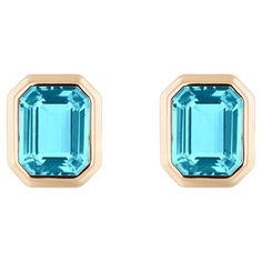 These Blue Topaz Emerald Cut Bezel Set Stud Earrings in 18K Yellow Gold from the 'Manhattan' Collection are an exquisite pair of earrings that exude elegance and sophistication. These earrings feature vibrant blue topaz gemstones with a captivating emerald-cut shape, carefully set in a luxurious 18K yellow gold bezel setting. The design is inspired by the sleek and modern aesthetics of Manhattan, making them a perfect choice for adding a touch of urban chic to any outfit. These stud earrings are Gem Earrings, Blue Topaz Earrings, Topaz Earrings, Timeless Accessories, Vibrant Blue, Urban Chic, Topaz Gemstone, Classic Beauty, Modern Aesthetics