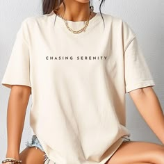 Chasing Serenity Minimalist Cotton T-shirt. Made With Love & Purpose. There's nothing better than a shirt that makes you feel comfortable and stylish at the same time. Style this inspirational tee with a skirt, jeans or leggings, add a piece of jewelry, put on your favorite shoes and you're ready to go make memories. This tee makes a perfect gift for your loved ones.  GENERAL INFORMATION - Comfort Colors® 1717 T-Shirt - Unisex Adult Sizing - Rolled Sleeves in pictures is for styling purposes  on Minimalist Graphic Print Short Sleeve Tops, Beige Relaxed Fit Tops With Letter Print, Beige Letter Print Relaxed Fit Tops, Minimalist Streetwear T-shirt, Minimalist Short Sleeve Letter Print T-shirt, Trendy Beige T-shirt For Everyday, Everyday Beige Tops With Letter Print, Beige Letter Print Top For Everyday, Trendy Beige Everyday T-shirt