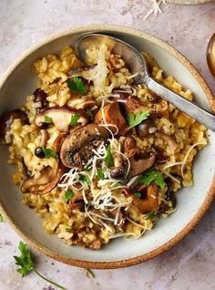 a bowl filled with rice, mushrooms and parmesan sprinkled on top