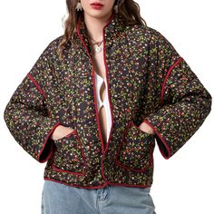 a woman with her hands on her hips wearing a black and red floral print jacket