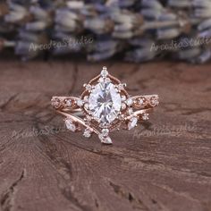 a close up of a ring on top of a wooden table with flowers in the background