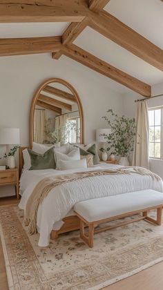 a large bed sitting in a bedroom on top of a wooden floor next to a window