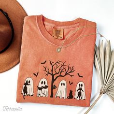 Get into the Halloween spirit with this Comfort Colors t-shirt or longsleeve shirt, featuring Cute ghosts cuddling with black cats sitting under a spooky haunted tree. This vintage-inspired design captures the eerie charm of Halloween, making it a cozy and stylish addition to your fall wardrobe. Perfect for trick-or-treating or any Halloween festivities, this tee combines comfort with a touch of spooky fun. Keep your drinks as cool as your style, they're the perfect addition to your Halloween en Spooky Long-sleeve Orange T-shirt, Spooky Long Sleeve Orange T-shirt, Spooky Orange Long Sleeve T-shirt, Spooky Long Sleeve T-shirt With Cartoon Print, Halloween Long Sleeve T-shirt With Screen Print, Orange Pre-shrunk Long Sleeve T-shirt, Spooky Cotton T-shirt With Cat Print, Spooky Fall Tops With Cat Print, Spooky Long Sleeve Screen Print T-shirt