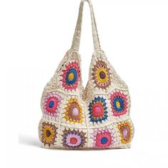 a white crocheted bag with multicolored flowers on the front and bottom