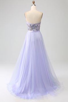 a dress on a mannequin with flowers in the front and purple tulle skirt