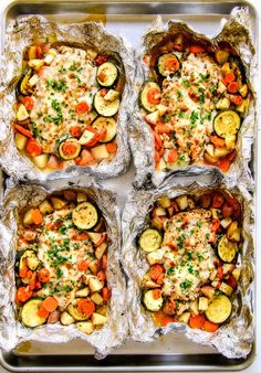 four trays filled with different types of food on top of tin foil covered in sauce