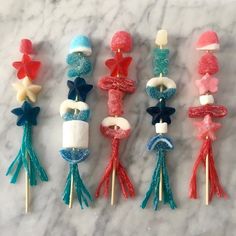 six cake toppers made to look like bows and tassels on toothpicks