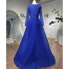 a blue evening gown on display in a room with white walls and wooden floors,