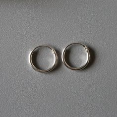 Delicate minimal sterling silver jewelry. Our products are made with 925 sterling silver and are hypoallergenic and nickel free! *Middle one in the picture ★ This listing is for a PAIR of hoops.  ★ Hoop dimensions 10mm outer diameter, 8mm inner diameter  1mm thickness ★ Material 925 sterling silver  Your earrings will come in a cute gift box! We will ship them out asap, shipping is fixed price for as many items as you want. Tiny Silver Classic Earrings, Tiny Classic Silver Earrings, Minimalist Nickel-free White Gold Jewelry, Minimalist Small Hoop Jewelry With Sterling Silver Clasp, Minimalist Sterling Silver Hoop Jewelry, Hypoallergenic White Gold Minimalist Jewelry, Everyday Hypoallergenic Sterling Silver Jewelry, Minimalist Small Hoop Sterling Silver Jewelry, Silver Round Minimalist Jewelry