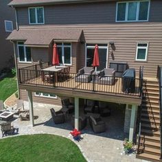 an aerial view of a house with patio furniture and umbrellas on the deck area